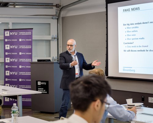 Lecturer at NYU in front of slide titled 'Fake News'